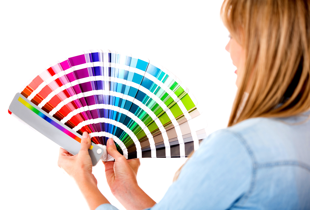 Female interior designer holding color guide - isolated over a white background